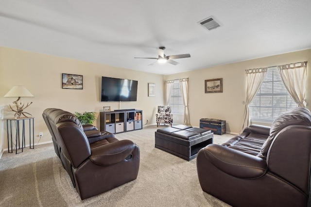 living room featuring visible vents, baseboards, a ceiling fan, and carpet flooring