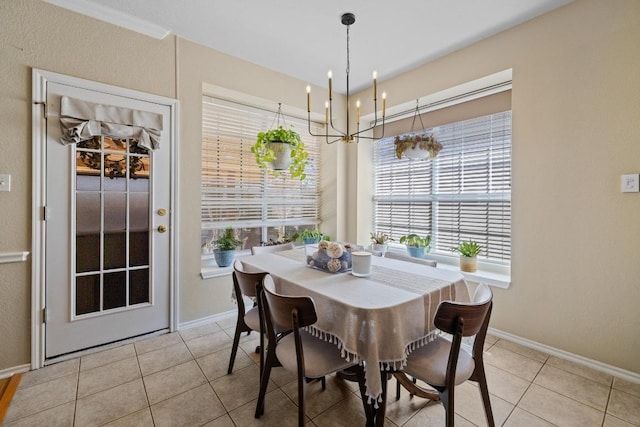 dining area featuring light tile patterned floors, a notable chandelier, and baseboards