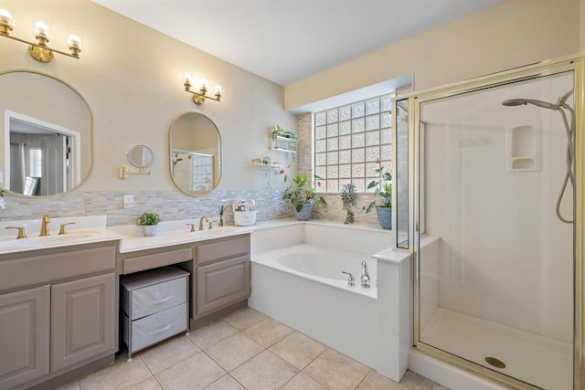 full bath featuring tile patterned floors, a sink, a shower stall, double vanity, and a bath