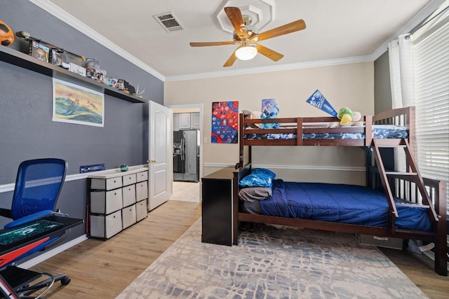 bedroom featuring crown molding, black fridge with ice dispenser, visible vents, and light wood-type flooring