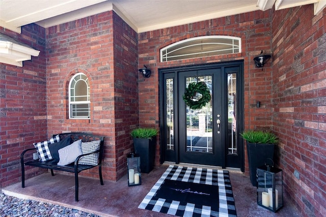 view of exterior entry featuring brick siding