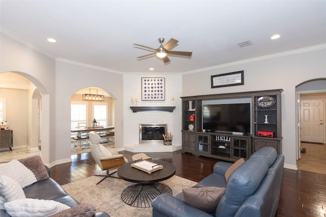 living room with hardwood / wood-style flooring, visible vents, arched walkways, and ceiling fan