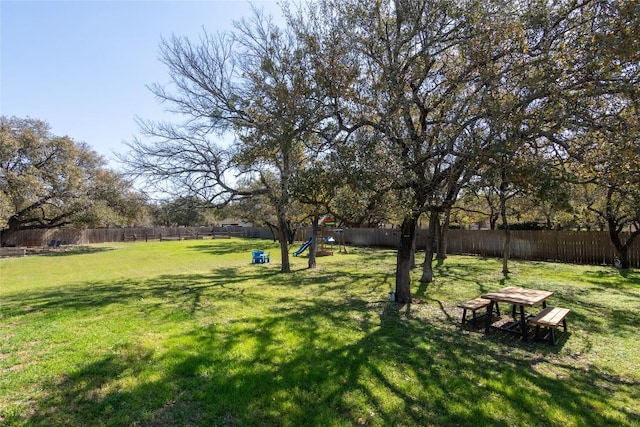 view of yard featuring a playground and a fenced backyard