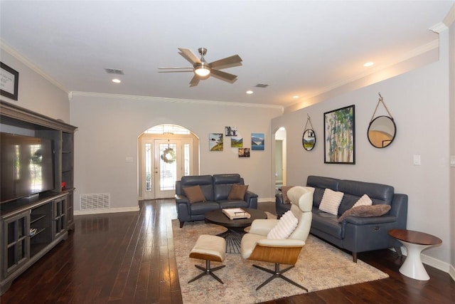 living room with visible vents, ornamental molding, arched walkways, a ceiling fan, and dark wood-style flooring