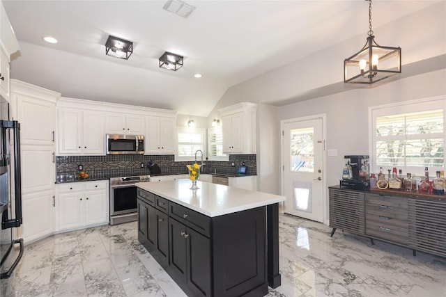 kitchen with marble finish floor, white cabinetry, stainless steel appliances, and vaulted ceiling