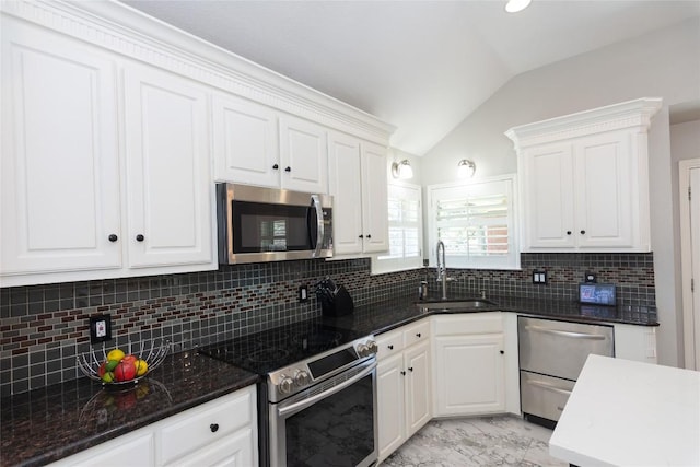 kitchen featuring lofted ceiling, stainless steel appliances, marble finish floor, white cabinetry, and a sink