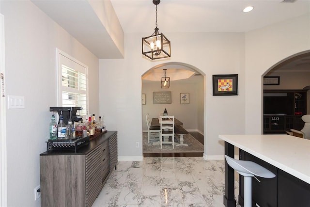 kitchen with baseboards, arched walkways, and marble finish floor