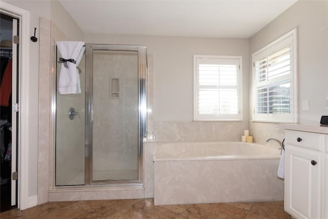 full bath with vanity, a stall shower, a walk in closet, tile patterned floors, and a bath