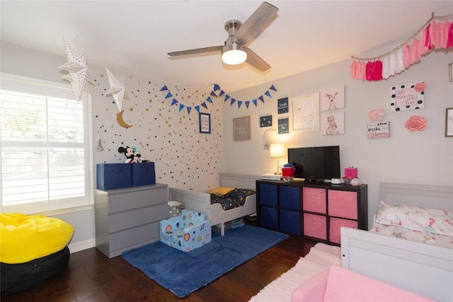 bedroom featuring baseboards, multiple windows, wood finished floors, and a ceiling fan