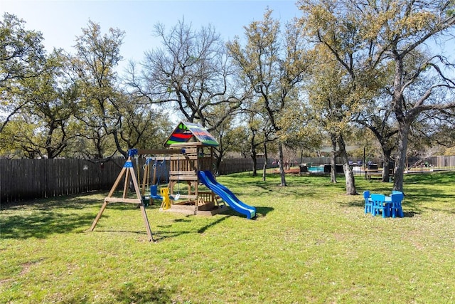 communal playground with a yard and a fenced backyard