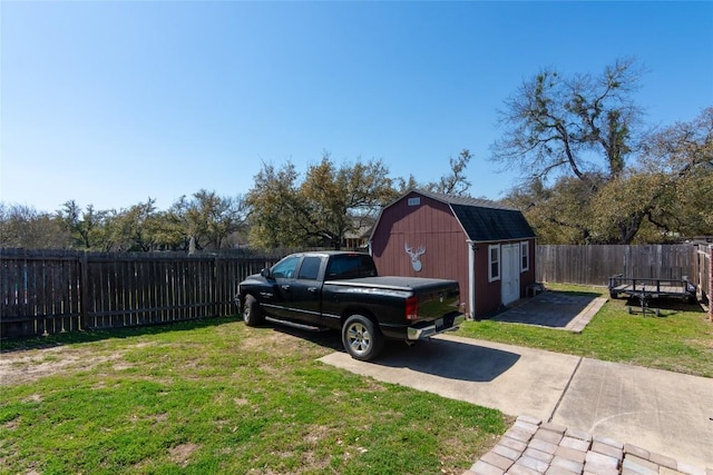 view of yard featuring an outdoor structure, a fenced backyard, and a barn