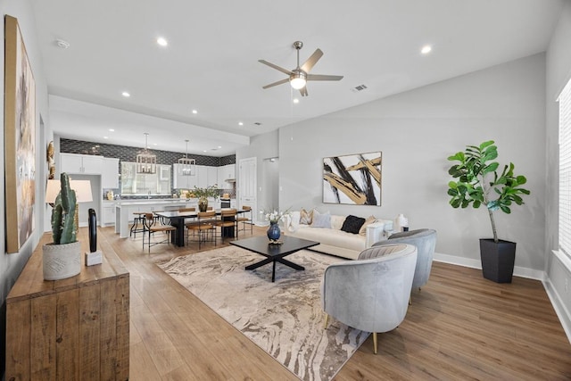 living area featuring visible vents, baseboards, recessed lighting, wood finished floors, and a ceiling fan