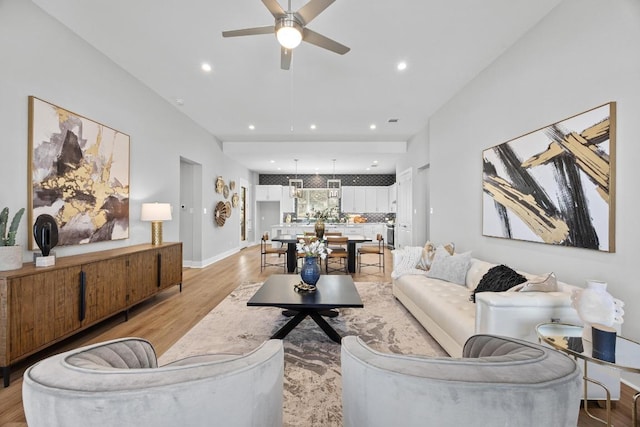 living room with recessed lighting, light wood-style flooring, baseboards, and ceiling fan