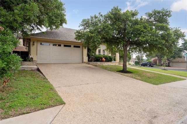 view of front of house featuring a front lawn, concrete driveway, stucco siding, stone siding, and an attached garage