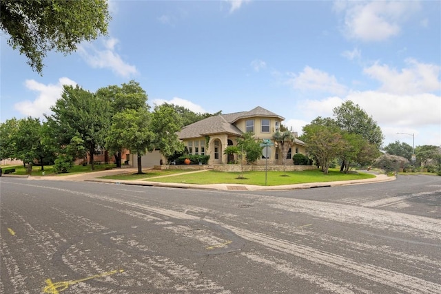 view of front of property featuring a front yard, a garage, and stucco siding