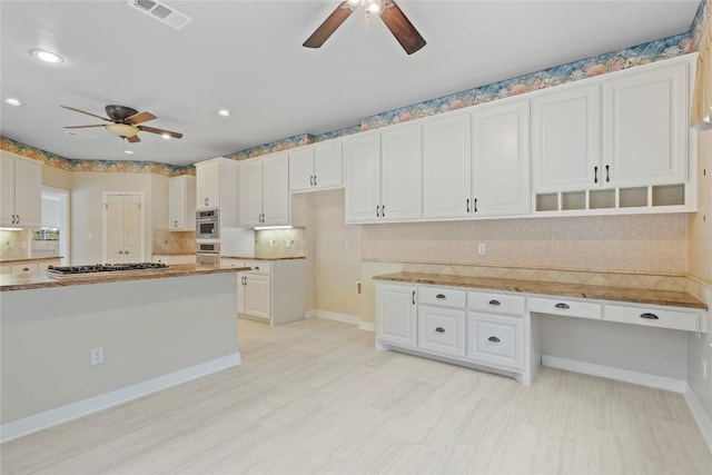 kitchen featuring visible vents, backsplash, white cabinetry, stainless steel gas stovetop, and ceiling fan