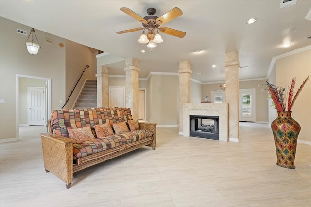 living area with visible vents, a ceiling fan, stairway, crown molding, and baseboards