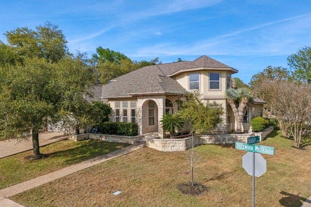 9907 Spicewood Mesa, Austin, TX 78759 - view of front of house with a front yard, a shingled roof, stucco siding, and stone siding