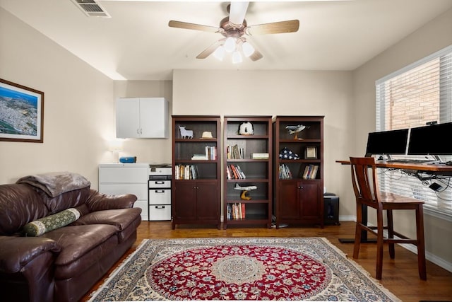 office area with visible vents, baseboards, a ceiling fan, and wood finished floors