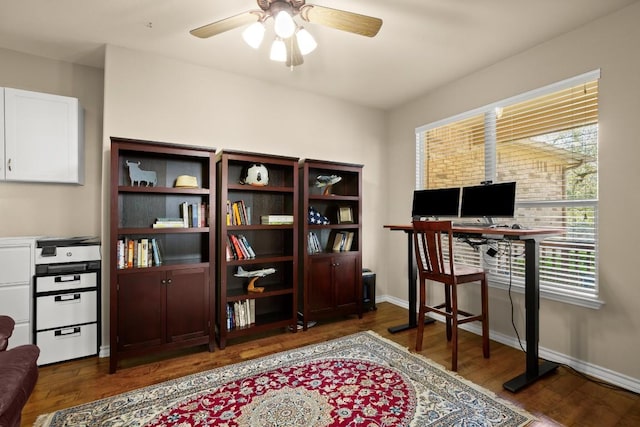 office featuring baseboards, ceiling fan, and dark wood-style flooring