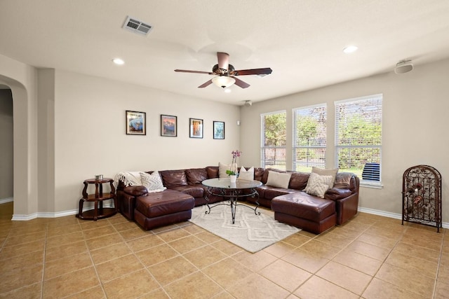 living room featuring a ceiling fan, visible vents, light tile patterned flooring, recessed lighting, and arched walkways