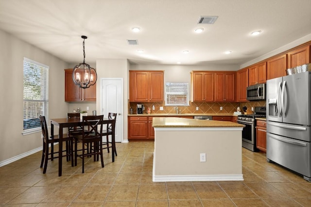 kitchen with a notable chandelier, visible vents, appliances with stainless steel finishes, and a center island