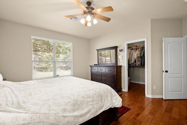 bedroom featuring a ceiling fan, hardwood / wood-style flooring, a closet, baseboards, and a spacious closet