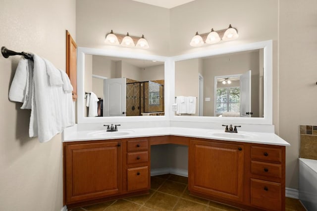 bathroom featuring double vanity, tile patterned flooring, a stall shower, and a sink