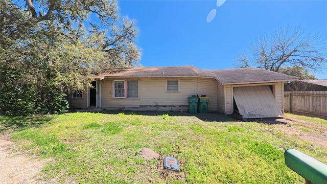 back of house with a lawn and fence