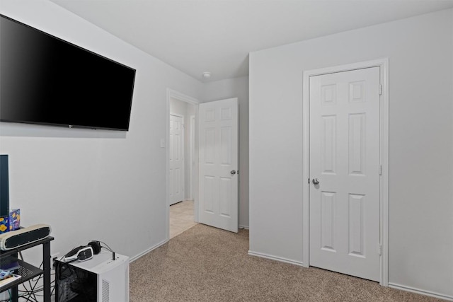 bedroom with baseboards and light carpet