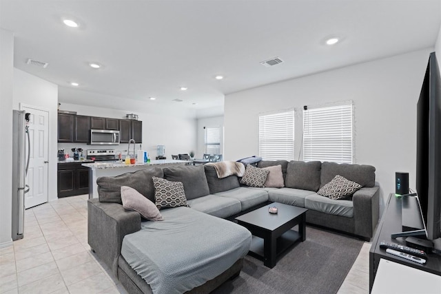 living area with light tile patterned floors, visible vents, and recessed lighting