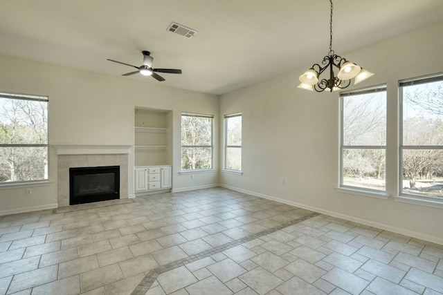 113 Yaupon Ln, Georgetown, TX 78633 - unfurnished living room with a ceiling fan, a tile fireplace, a chandelier, and built in shelves