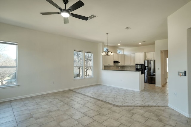 113 Yaupon Ln, Georgetown, TX 78633 - kitchen featuring stainless steel fridge with ice dispenser, open floor plan, a chandelier, a ceiling fan, and pendant lighting