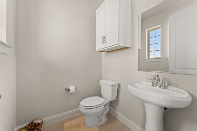 bathroom with toilet, baseboards, and a sink