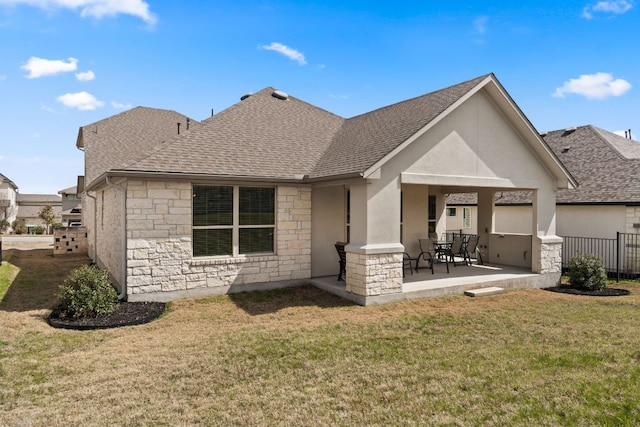 rear view of property featuring stone siding, a yard, a patio, and stucco siding