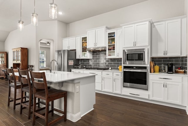 kitchen featuring under cabinet range hood, stainless steel appliances, dark wood-style floors, and light countertops