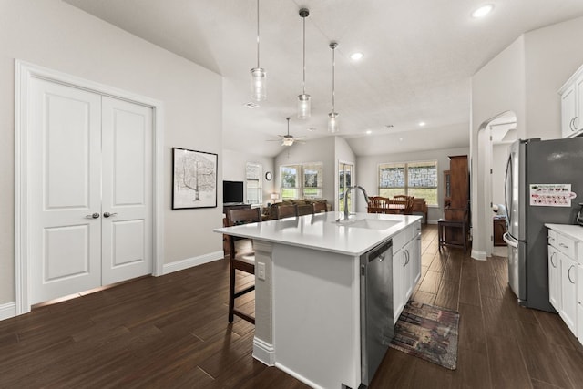 kitchen featuring dark wood-style floors, stainless steel appliances, a kitchen bar, and a sink