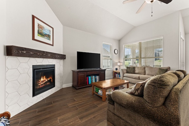 living area featuring a glass covered fireplace, a ceiling fan, lofted ceiling, and wood finish floors