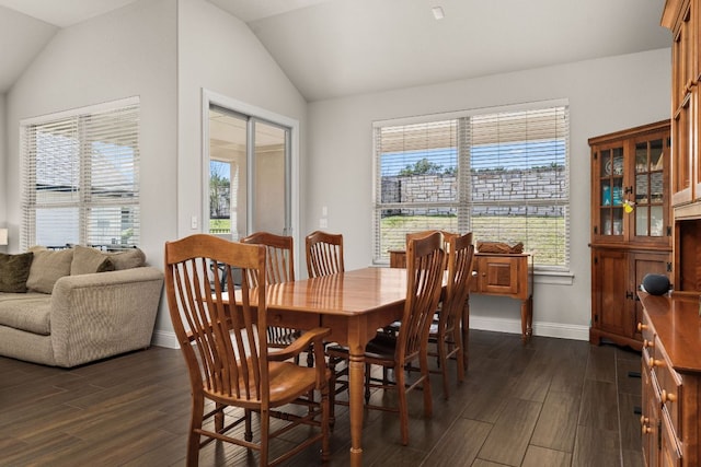 dining room featuring baseboards, lofted ceiling, and dark wood finished floors