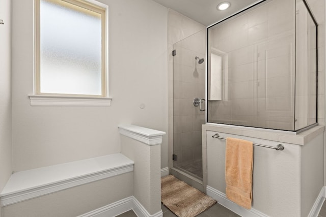 full bathroom featuring a stall shower and baseboards