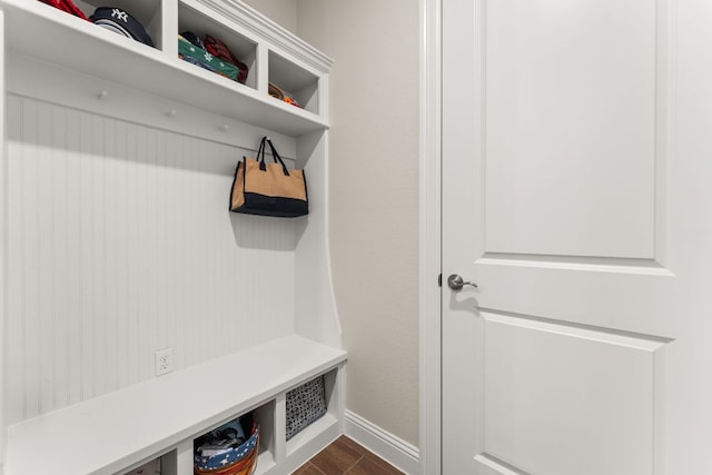 mudroom featuring dark wood finished floors and baseboards