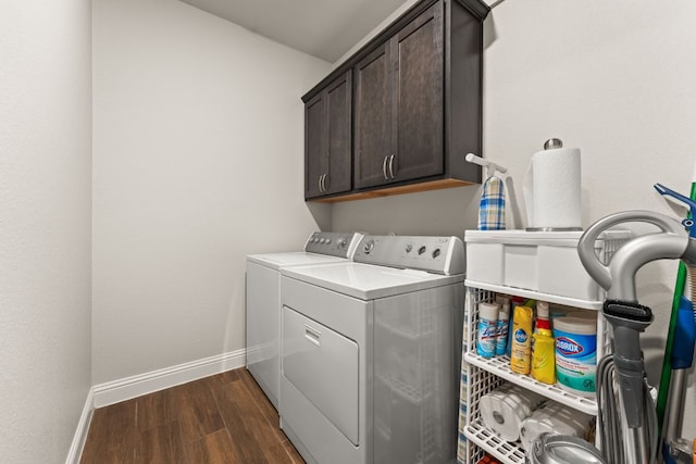 laundry room featuring dark wood finished floors, cabinet space, baseboards, and washer and clothes dryer