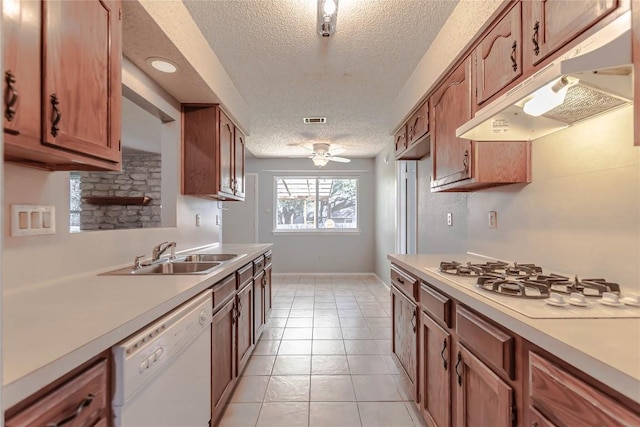 kitchen with under cabinet range hood, white appliances, light countertops, and a sink