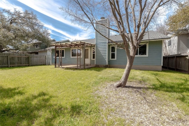 rear view of property featuring a lawn, a chimney, a fenced backyard, a pergola, and a patio