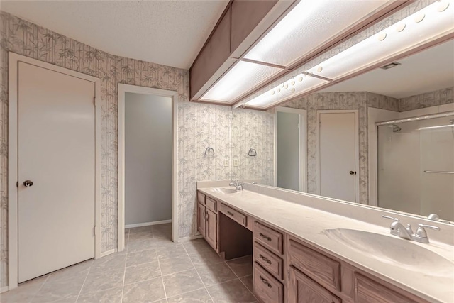 bathroom featuring wallpapered walls, tile patterned flooring, and a sink