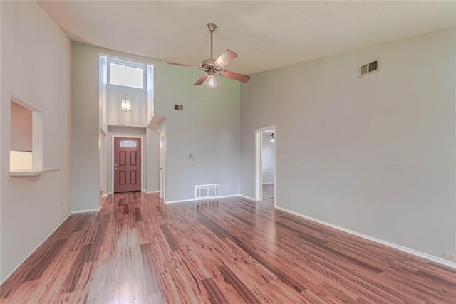 entrance foyer with a ceiling fan, wood finished floors, visible vents, and baseboards