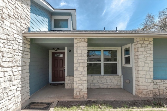 property entrance with stone siding and covered porch