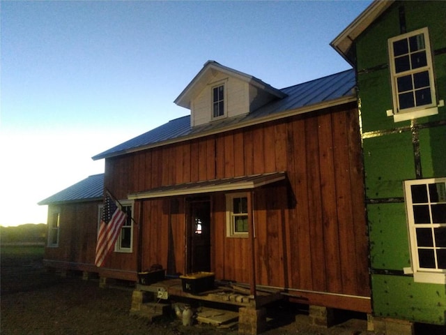 rear view of house with metal roof and a standing seam roof