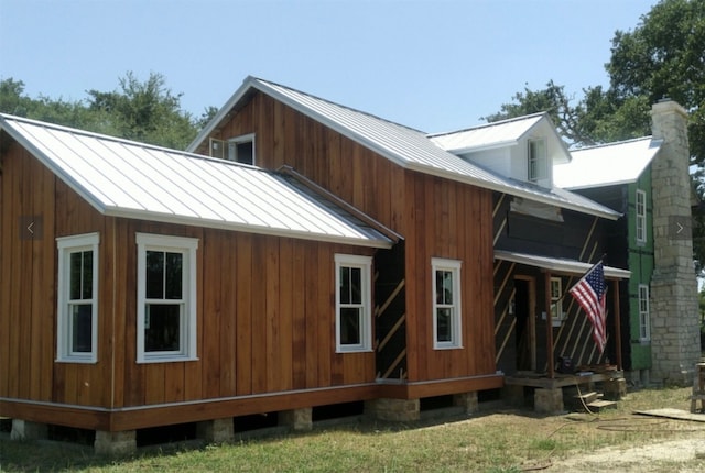 view of home's exterior featuring metal roof and a chimney