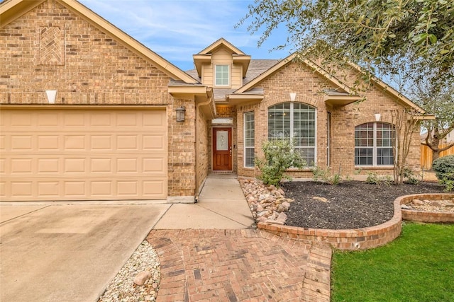 view of front of home with a garage, brick siding, and driveway